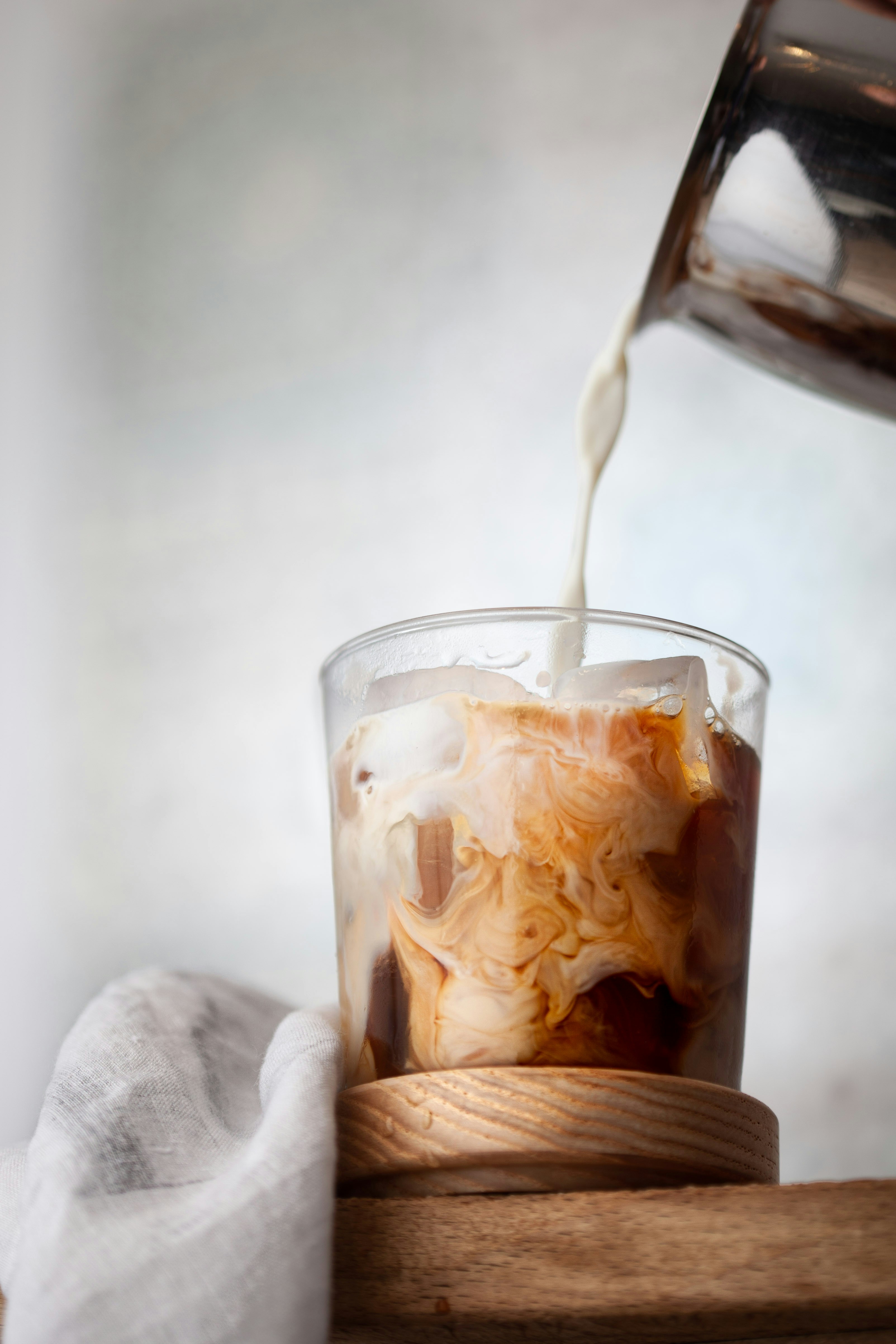 Milk pouring into iced coffee